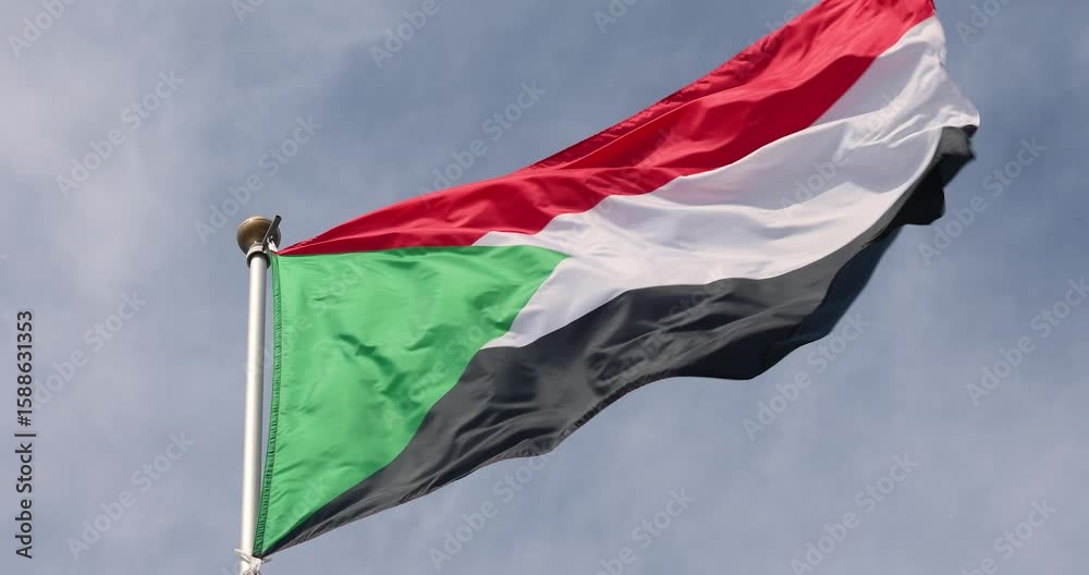 The flag of Sudan is captured in close-up. The flag of Sudan fluttering against the blue sky is the national symbol of Sudan. Great for news. The video is presented in 4K format.