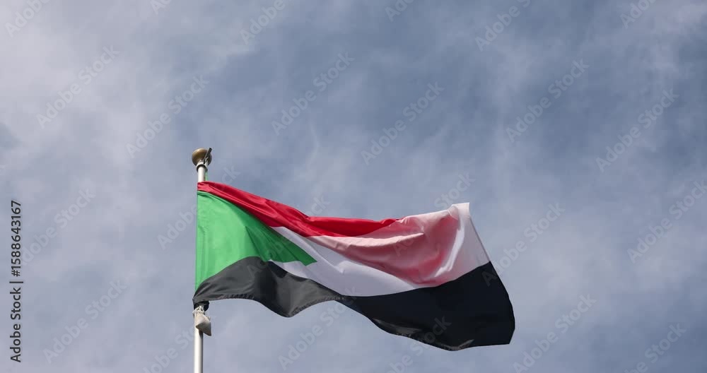 The flag of Sudan is captured in close-up. The flag of Sudan fluttering against the blue sky is the national symbol of Sudan. Great for news. The video is presented in 4K format.