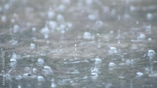 Close-Up of Rain Making Waves in Small Puddle

