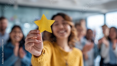 Woman holds a golden star, celebrating success with a supportive team in the background.