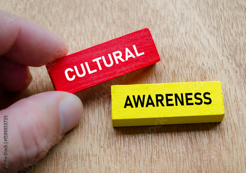 Cultural Awareness shown by hand holding red and yellow wooden blocks. Diversity and inclusion concept