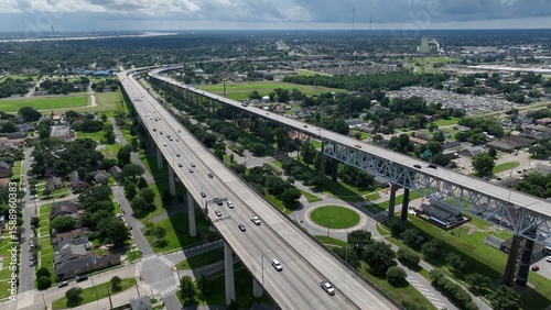 Cars traveling on U.S. Highway 90 over residential homes and public parks in New Orleans, Louisiana about the cross the Mississippi River on the Crescent City Connectdion Bridge