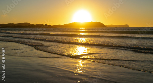 Beautiful sunrise at Praia do Forte, with the sun illuminating the sands and the sea water, leaving them with golden tones. Cabo Frio, Rio de Janeiro.