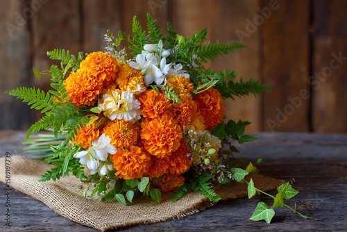 A dynamic composition of orange marigolds, lavender, and white jasmine, surrounded by a mix of green ferns and trailing ivy.