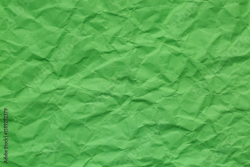 Close-up of green crumpled paper texture,A close-up, top-down shot showcases the crinkled and uneven texture of green paper. Background concept.
