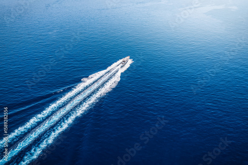 Fototapeta Naklejka Na Ścianę i Meble -  Aerial view of a luxury yacht sailing over the blue, mediterranean sea in Greece, with copy space