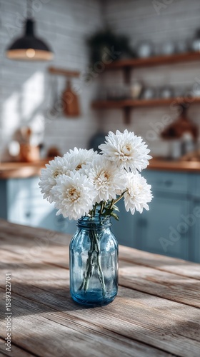 White Daisies in a Blue Glass Jar on a Wooden Table in a Bright Kitchen Setting.