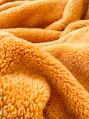 Soft orange blanket draped across a couch in cozy living room setting
