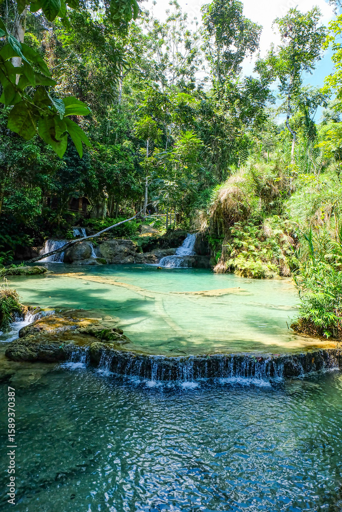 Naklejka premium Most magnificent and breathtaking nature of Kuang Si waterfall and cascade and its green, emerald crystal clear water and lake in Luang Prabang 