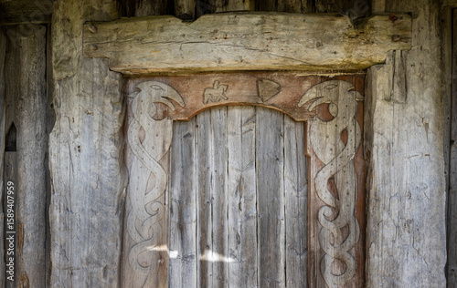 heavy wooden door with Norse motifs carved in at the viking village of Vestrahorn, Iceland