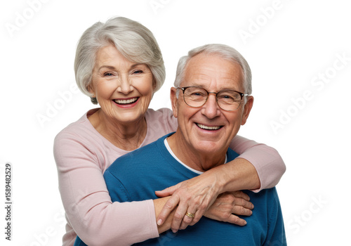 Elderly caucasian woman with grey hair in pink top embracing elderly caucasian man with grey hair in blue sweater and glasses, both smiling broadly on transparent studio background with copy