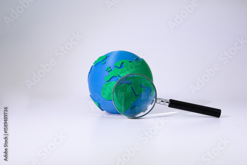 Earth Globe with Magnifying Glass. Environmental Research. Earth model with magnifying glass symbolizing detailed environmental study, climate research, and planetary investigation. Earth day concept
