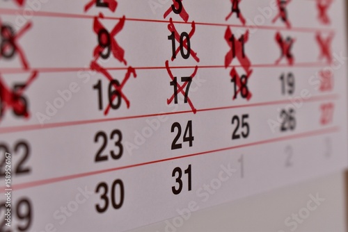 Marked calendar with red Xs over certain dates. Symbol of waiting, planning, and time tracking.