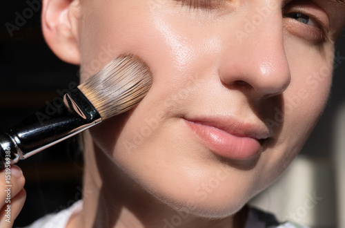 Canvastavla Close-up of a woman applying foundation with brush on cheek