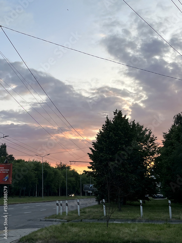 Fototapeta Naklejka Na Ścianę i Meble -  A magical summer evening with a warm golden sunset that floods the streets of a small town with soft light