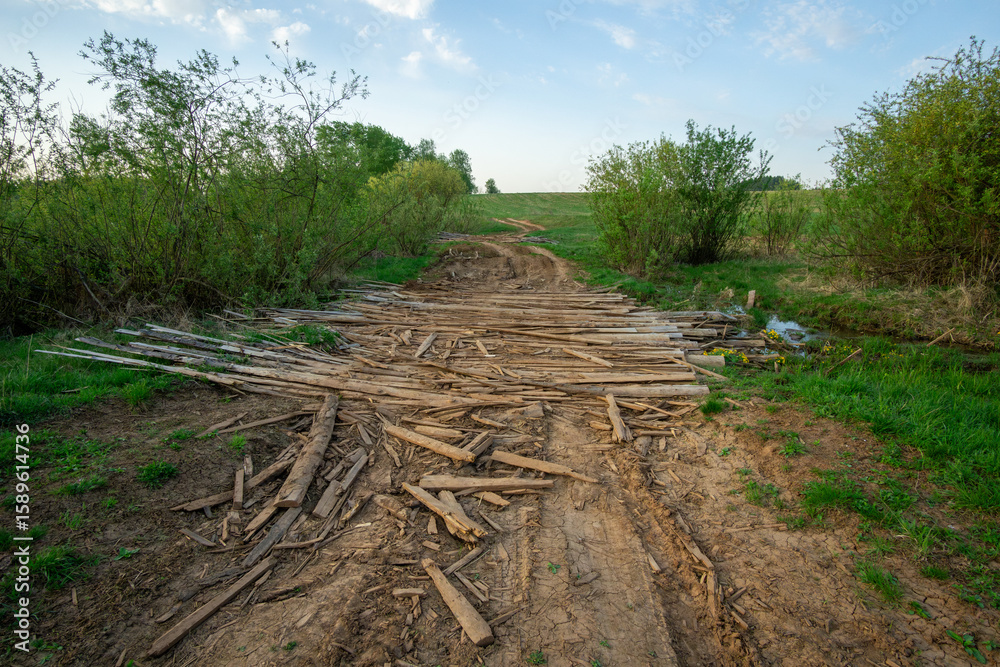 Dirt path leading through lush greenery, with scattered wooden planks creating a rustic trail, inviting exploration in a serene natural environment with soft sunlight Dirt path leading through lush greenery, with scattered wooden planks creating a rustic trail, inviting exploration in a serene natural environment with soft sunlight