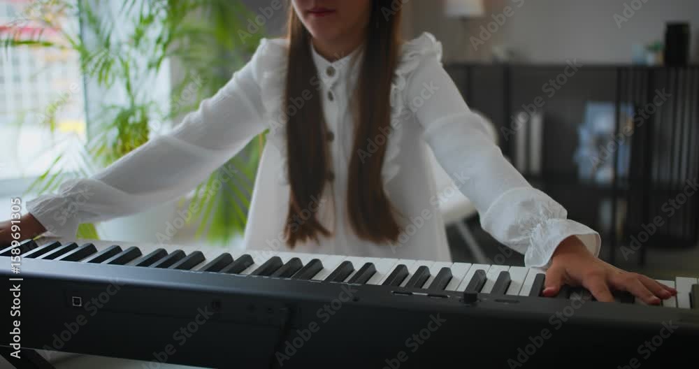 Tired girl slumps over digital piano keys after long music practice at home. Exhaustion during piano training