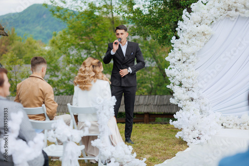Celebratory wedding ceremony with officiant and guests in natural outdoor setting