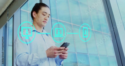 Business professional tapping smartphone and activating linked teal icons showing tech connectivity