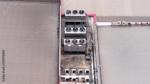 Cooling towers in data center building. Air conditioning cooling towers in front of building with fins to the front. Industrial cooling towers or air cooled water chillers with piping system.