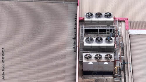Cooling towers in data center building. Air conditioning cooling towers in front of building with fins to the front. Industrial cooling towers or air cooled water chillers with piping system.