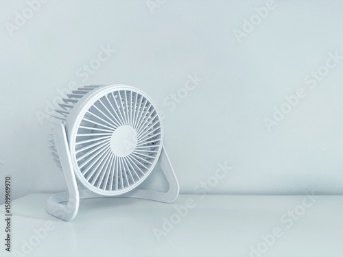 Wallpaper Mural A small, white portable fan sits on a matching white surface against a plain background. Concept of: Minimalist cooling.
 Torontodigital.ca