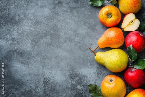 Fresh Fruit Arrangement Featuring Apples and Pears on a Textured Gray Surface