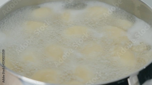 Fresh ravioli dumplings simmer in a pot of boiling water, releasing delicious aromas.