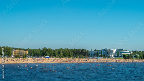 Finland. Sandy beach of Oulu city. Many people relax on a hot summer day on the sea beach.