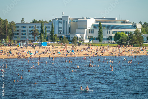 Finland. Sandy beach of Oulu city. Many people relax on a hot summer day on the sea beach.