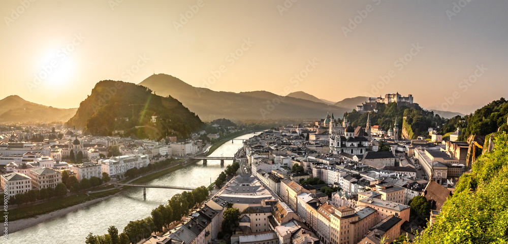 Obraz premium View of Salzburg from Monchsberg hill at sunrise, with Salzach river, castle and hills in background