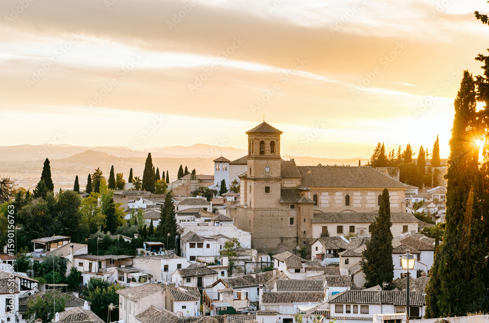 Fototapeta premium Sunset view of Granada from Mirador de la Cruz de Rauda with Iglesia de San Cristobal and city rooftops