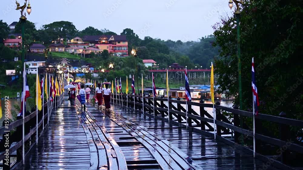 Mon ethnic women walk and carry things on their heads on the Mon wooden bridge, the longest wooden bridge in Mon village Sangklaburi Kanchanaburi,Thailand.