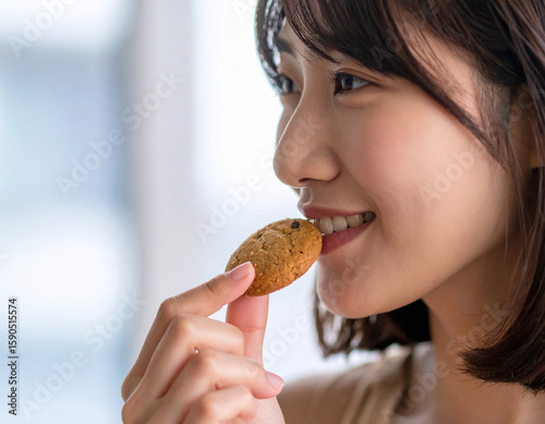 クッキーを食べる若い女性/
young woman eating cookies