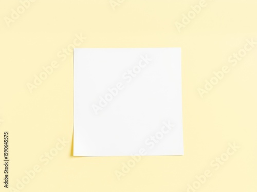 A blank white square paper sheet placed on a pale yellow background with soft lighting and simple composition