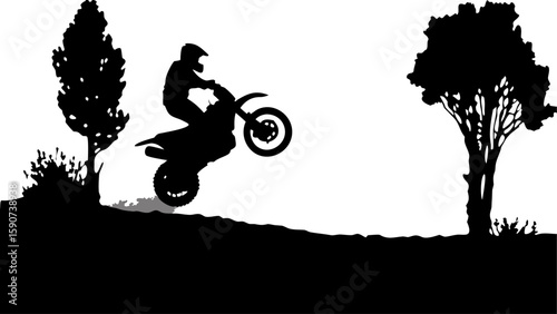 Silhouette of a motocross rider performing a wheelie on a dirt hill with trees in the background scene view