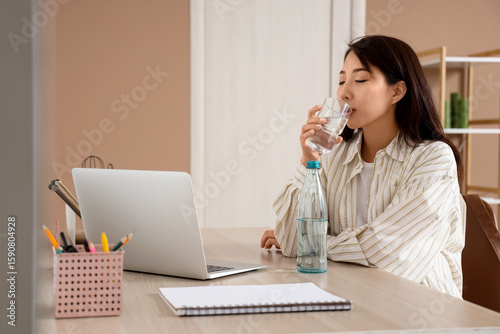 Young Asian woman drinking ...