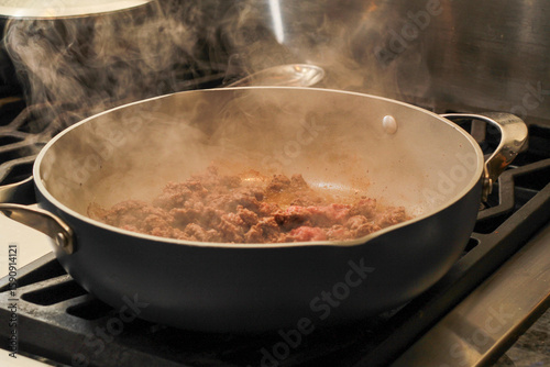 Steaming ground beef being sauted in pan on stovetop