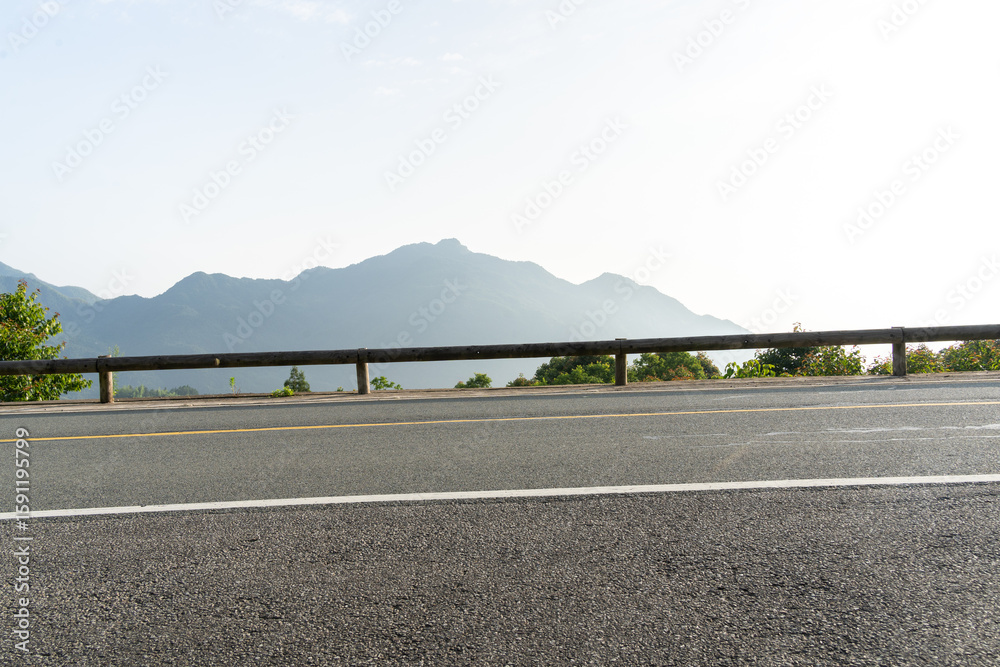 Fototapeta premium empty asphalt through mountain as background