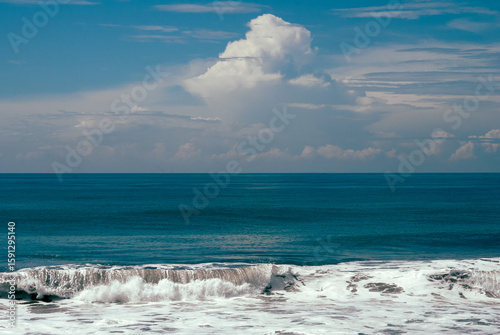 Powerful ocean wave breaking on volcanic beach