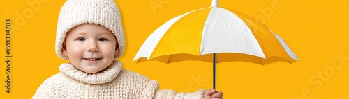 A cheerful baby holds a bright umbrella against a yellow background.
