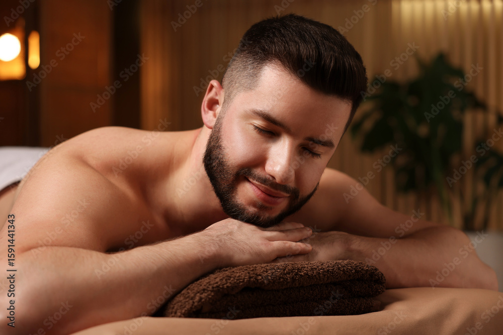 Obraz premium Handsome man lying on massage table in spa salon