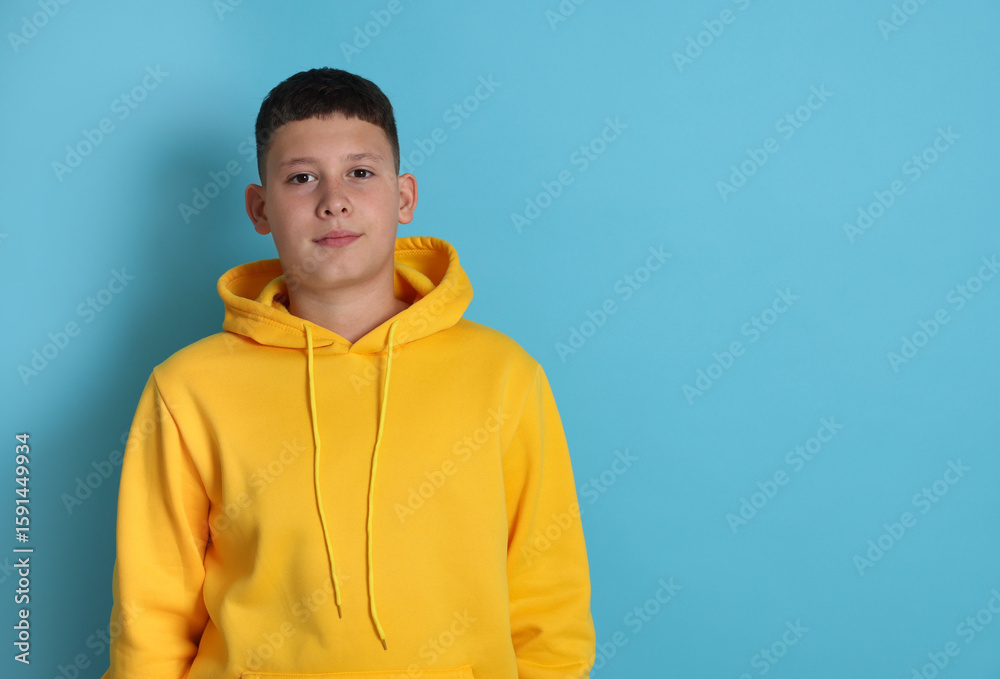 Portrait of teenage boy on light blue background, space for text Portrait of teenage boy on light blue background, space for text