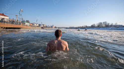 Vilnius, Lithuania - April 30, 2022: A boy bathes in icy water as part of cold therapy and mindfulness practice