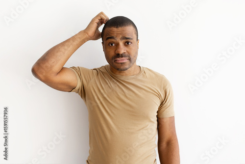 Φωτογραφία Confused black man scratching his head with uncertain expression