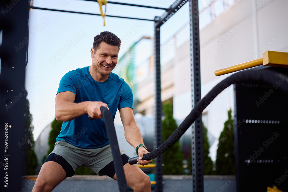 Εκτύπωση καμβά Happy athlete working out with battle ropes in health club