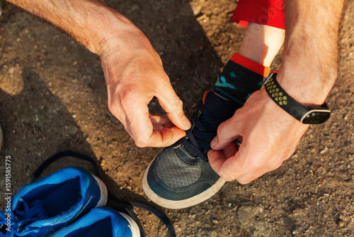 A man repairs children's sneakers. Close-up of hands and sneakers. Shoemaker. Jack of all trades. Home handyman.
