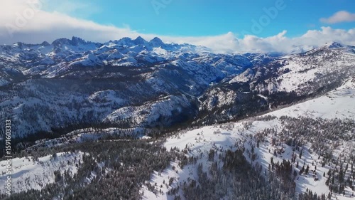 Mammoth Mountain ski resort California Hemlocks panorama Winter Spring Minarets Summit vista Ritter Sierra Nevada range sunny blue sky snowy clouds over jagged peaks Inyo Sierras National Forest pan