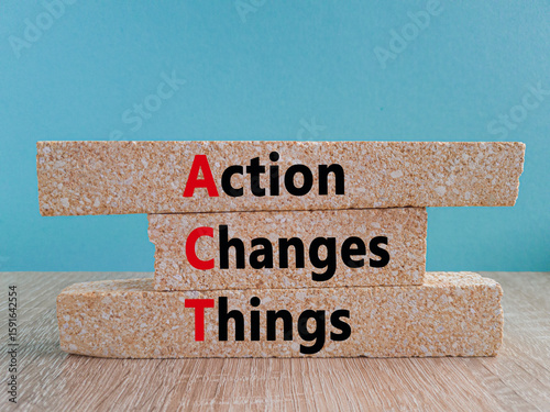 Brick blocks with words Action, Changes and Things. Wooden table, set against a blue. Symbolizes the process of taking action to implement changes in various aspects of life or business.