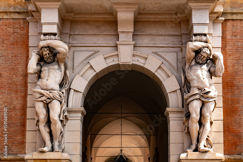 Tableau sur toile Two muscular caryatid statues holding up a classical portico in historic Italian building